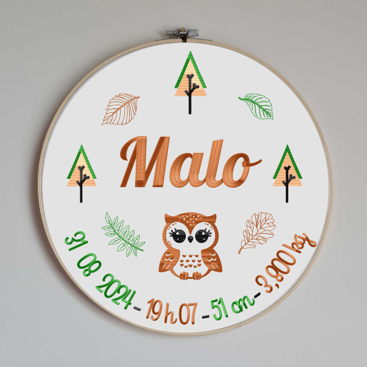 cercle en bois avec un tissu en coton blanc brodé avec les informations de naissance de bébé (prénom, taille, poids, date et heure de naissance) sur le thème de la forêt avec un hibou / une chouette