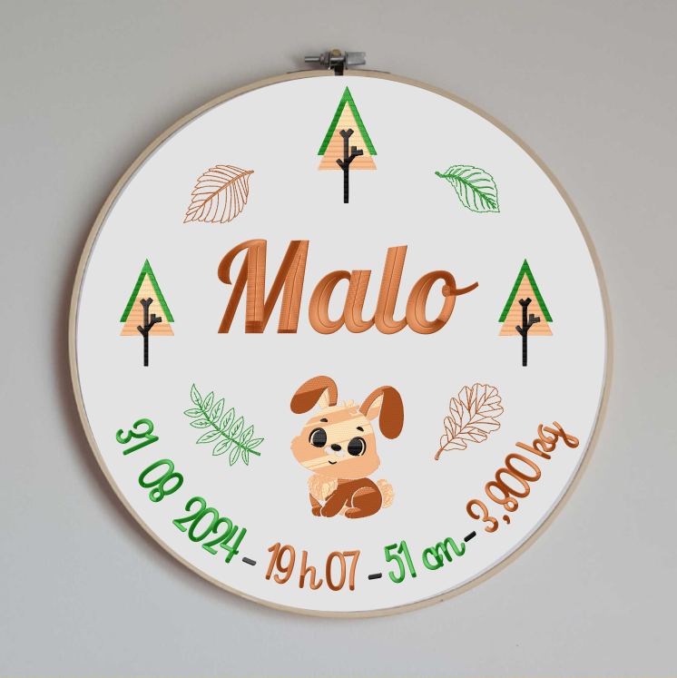 cercle en bois avec un tissu en coton blanc brodé avec les informations de naissance de bébé (prénom, taille, poids, date et heure de naissance) et des motifs sur le thème de la forêt avec un lapin