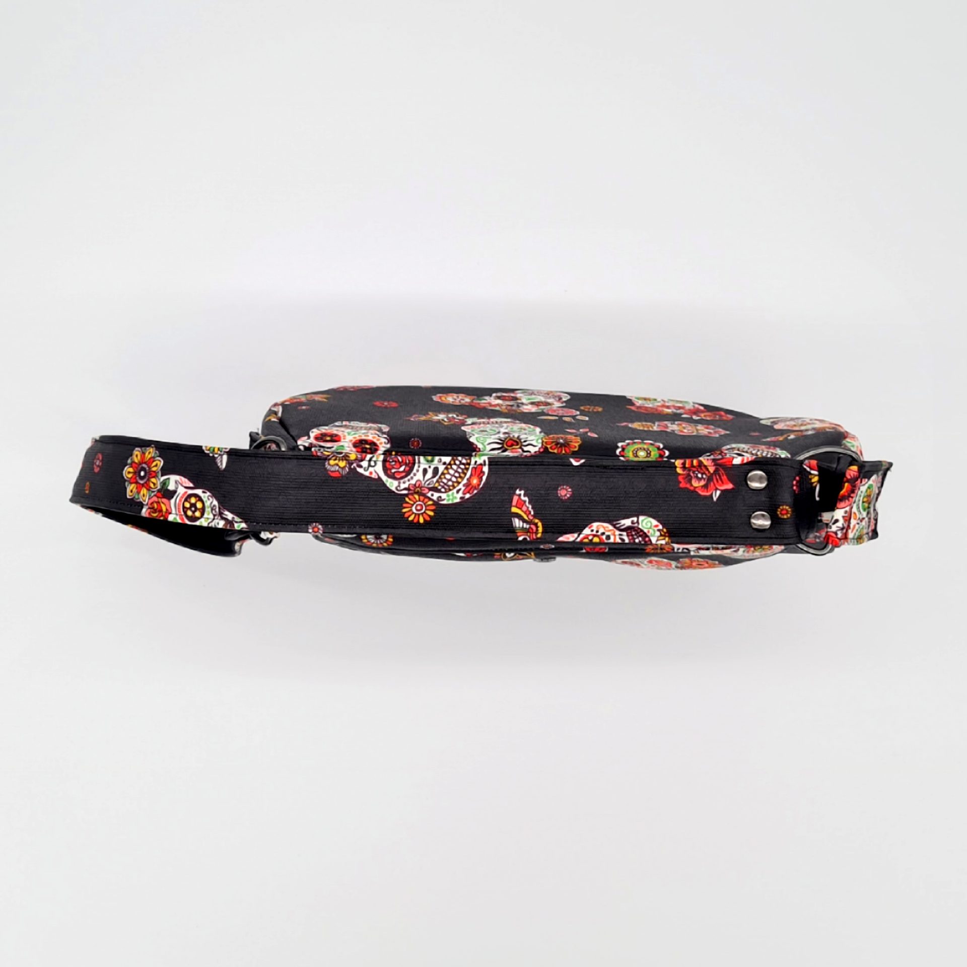 Sac à main couleur noir avec des motifs de têtes de mort mexicaines vu du dessus