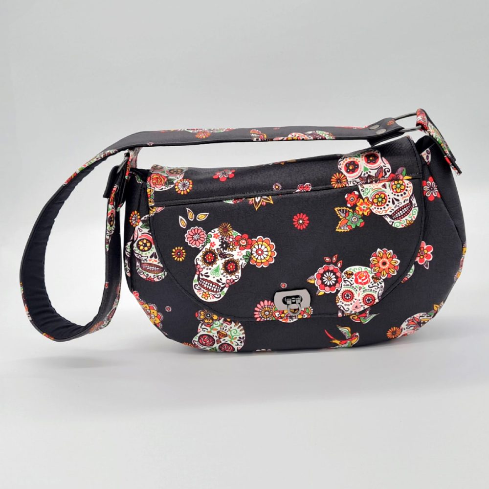 Sac à main couleur noir avec des motifs de têtes de mort mexicaines vu de face