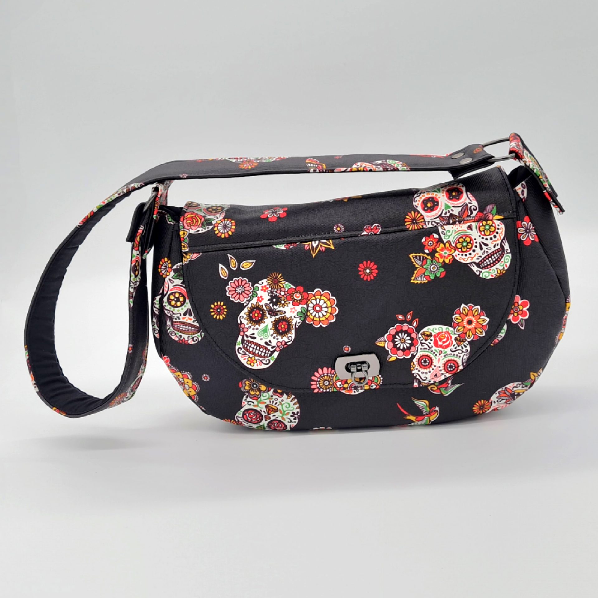 Sac à main couleur noir avec des motifs de têtes de mort mexicaines vu de face